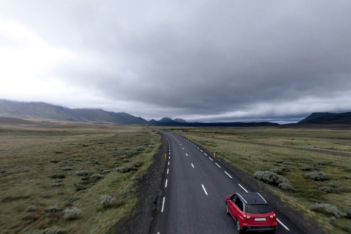 A red car driving on an open road