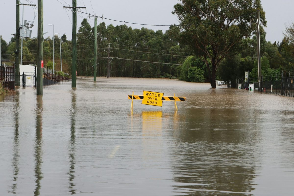 A flooded street with a submerged road sign